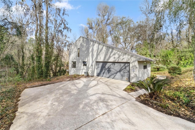 view of side of home with driveway and an attached garage