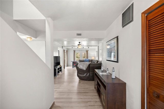 hall featuring light wood-style flooring and visible vents