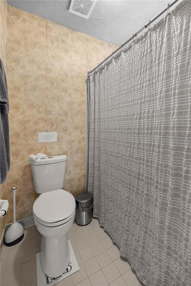 bathroom featuring toilet, visible vents, a shower with shower curtain, and tile patterned floors