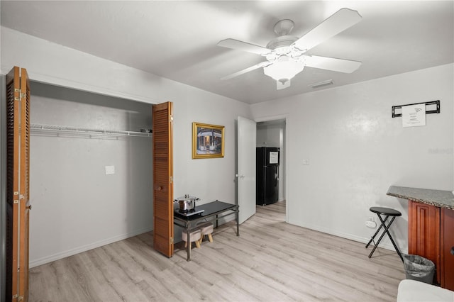 interior space with light wood-style floors, visible vents, baseboards, and a ceiling fan