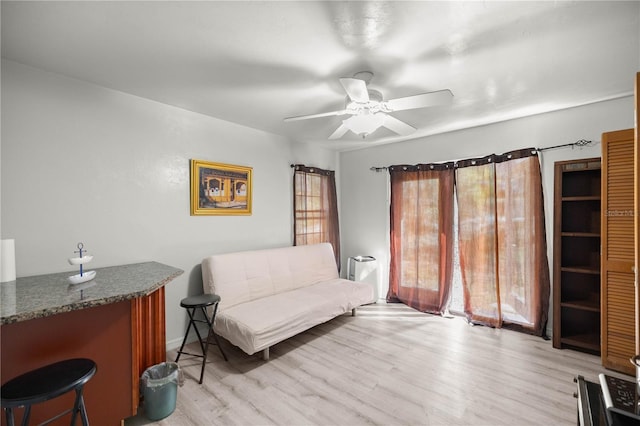 living area with light wood-style floors and a ceiling fan