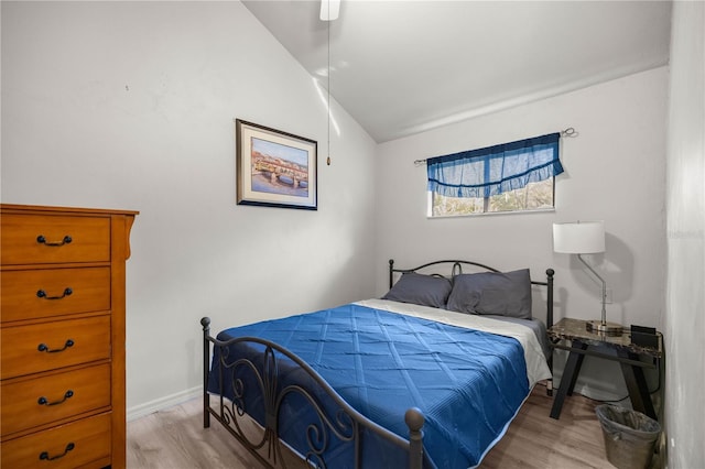 bedroom with vaulted ceiling, ceiling fan, baseboards, and light wood-style floors