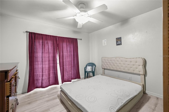 bedroom with a ceiling fan, baseboards, and wood finished floors