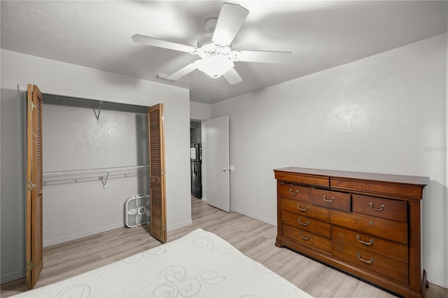 bedroom featuring a closet, visible vents, light wood-style flooring, a ceiling fan, and baseboards