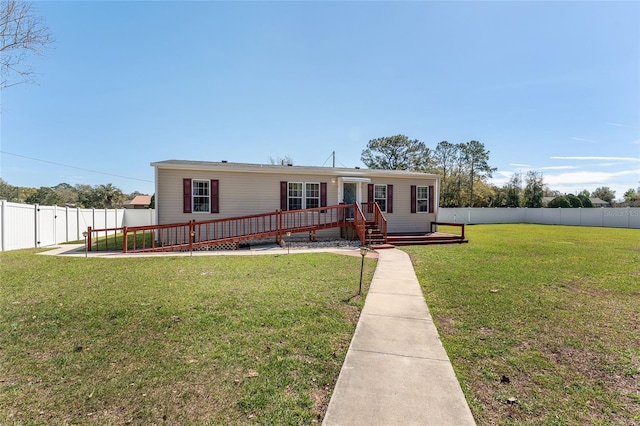 manufactured / mobile home with a wooden deck, a fenced backyard, and a front yard