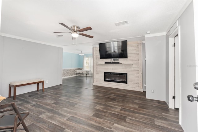 unfurnished living room featuring ceiling fan, visible vents, wood finished floors, and a fireplace