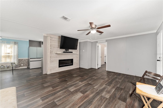 unfurnished living room with visible vents, a large fireplace, dark wood finished floors, and crown molding