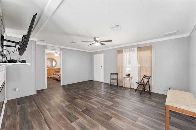 unfurnished room with visible vents, ornamental molding, wood finished floors, a textured ceiling, and a ceiling fan