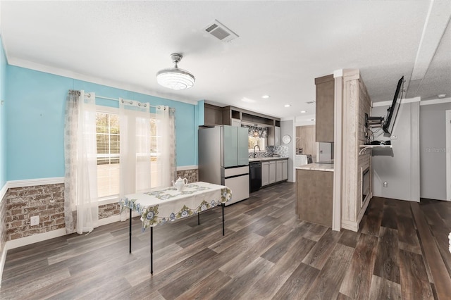 kitchen featuring visible vents, dark wood finished floors, freestanding refrigerator, light countertops, and black dishwasher