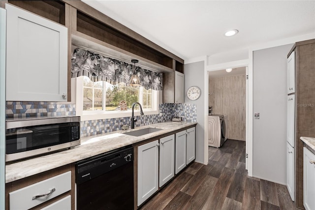 kitchen with dark wood finished floors, separate washer and dryer, a sink, dishwasher, and stainless steel microwave