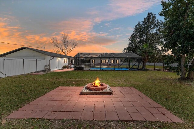 exterior space featuring a lanai, a yard, a patio area, and an outdoor fire pit