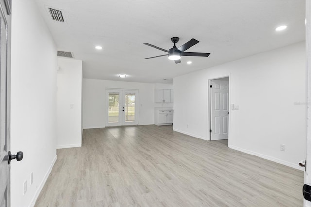 unfurnished living room featuring light wood-type flooring, french doors, visible vents, and baseboards