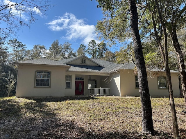 ranch-style house with covered porch and stucco siding