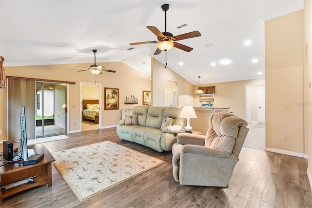 living area featuring lofted ceiling, baseboards, visible vents, and wood finished floors