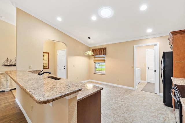 kitchen with black appliances, crown molding, arched walkways, and a sink