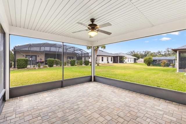 unfurnished sunroom featuring a ceiling fan