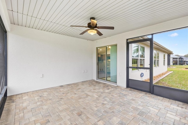 unfurnished sunroom featuring ceiling fan