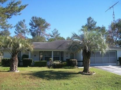 ranch-style home with a garage, a front lawn, and concrete driveway