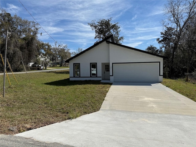 mid-century modern home featuring a garage, a front yard, driveway, and stucco siding