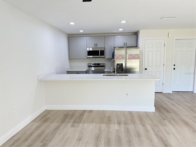31 Juniper Pass Ln, Ocala, FL 34480 - kitchen with appliances with stainless steel finishes, a sink, light wood-style flooring, light countertops, and recessed lighting