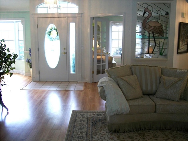 foyer entrance with plenty of natural light, crown molding, and wood finished floors