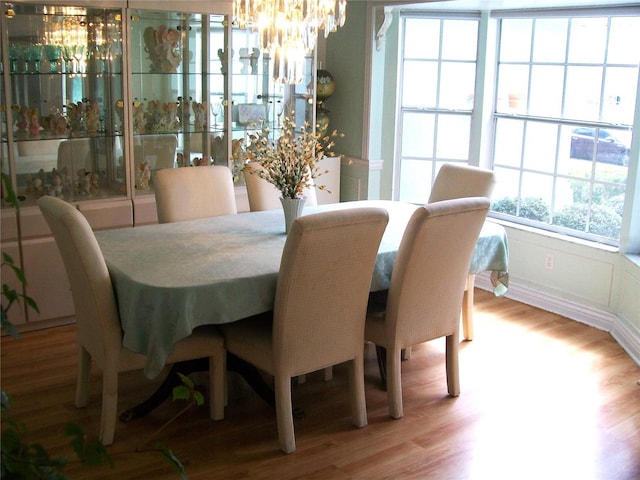 dining area with a chandelier and wood finished floors