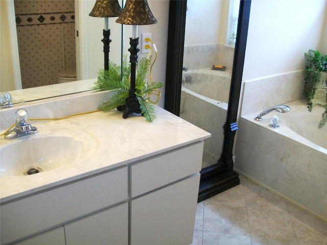 full bath with a garden tub, vanity, toilet, and tile patterned floors