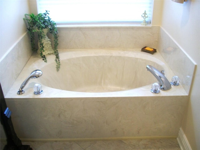 full bath with a healthy amount of sunlight, a garden tub, and tile patterned floors