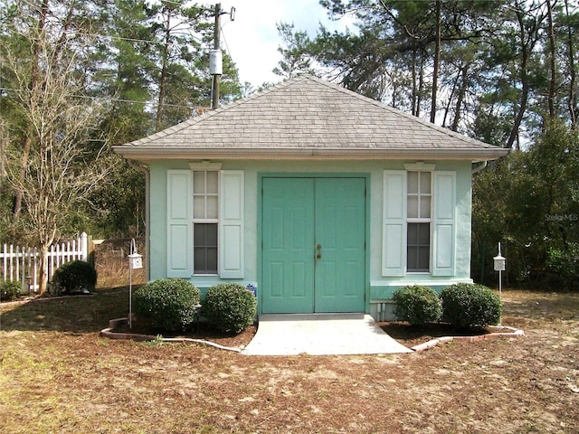 view of outbuilding featuring fence and an outdoor structure