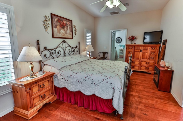 bedroom featuring a ceiling fan, wood finished floors, visible vents, and baseboards