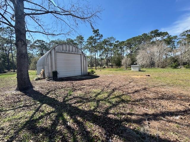 view of yard featuring an outbuilding and a detached garage