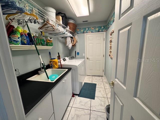 laundry area featuring visible vents, marble finish floor, a sink, cabinet space, and separate washer and dryer