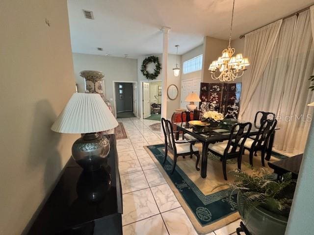 dining area with an inviting chandelier, visible vents, and marble finish floor