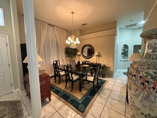 dining space with a chandelier, visible vents, and light tile patterned floors