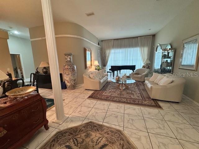 living area with decorative columns, baseboards, and visible vents