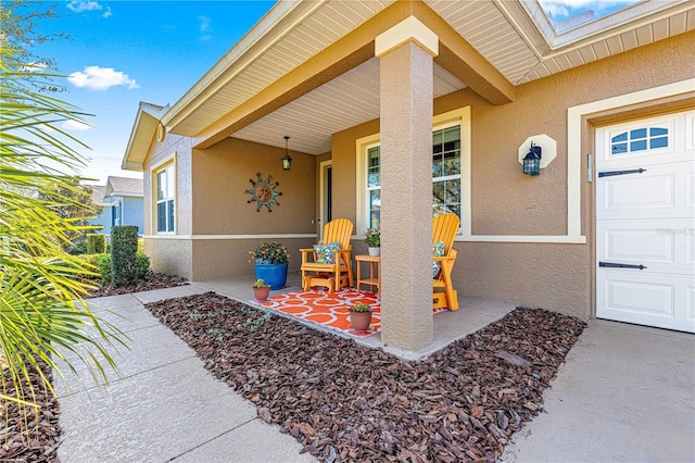 property entrance with a porch and stucco siding