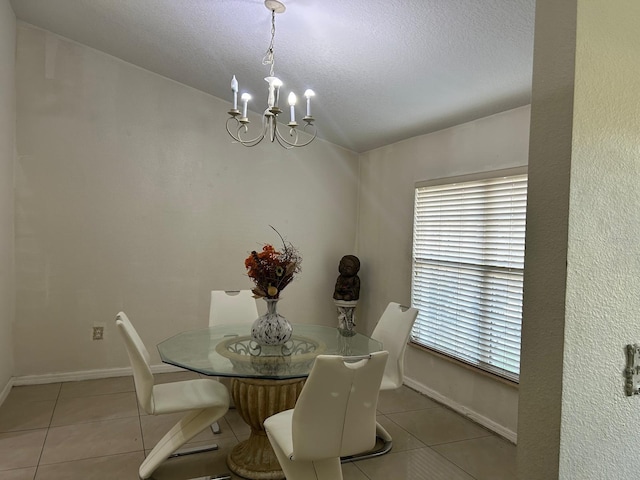 dining space featuring a chandelier, a textured ceiling, baseboards, and tile patterned floors