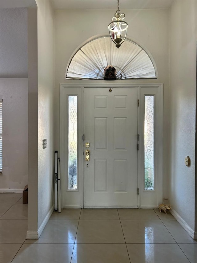 foyer entrance featuring baseboards and light tile patterned flooring