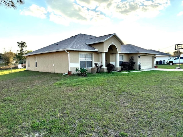 ranch-style house with a garage, concrete driveway, roof with shingles, stucco siding, and a front lawn