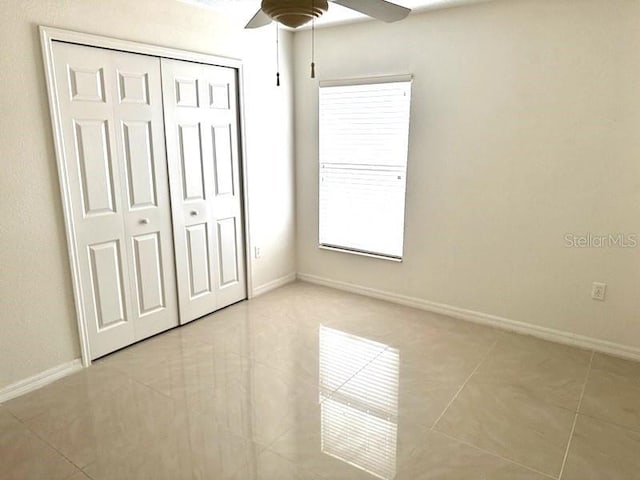 unfurnished bedroom featuring a closet, a ceiling fan, and baseboards