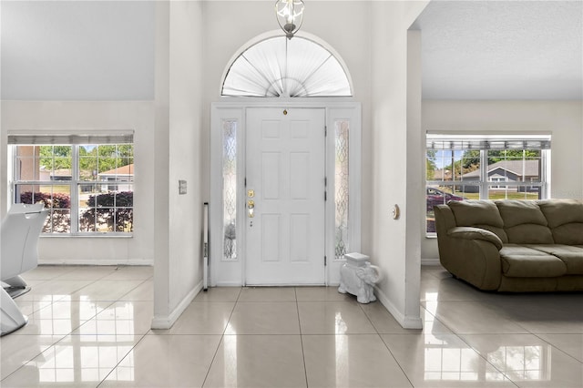 foyer with baseboards and tile patterned flooring