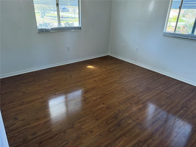 unfurnished room featuring dark wood finished floors and baseboards