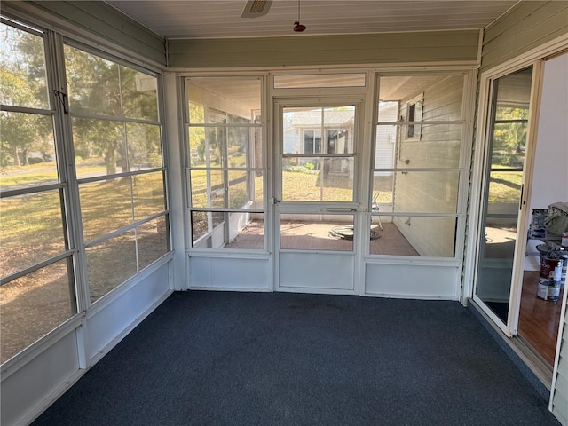 unfurnished sunroom featuring a ceiling fan