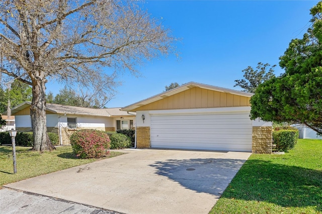 ranch-style house featuring a front yard, brick siding, driveway, and an attached garage