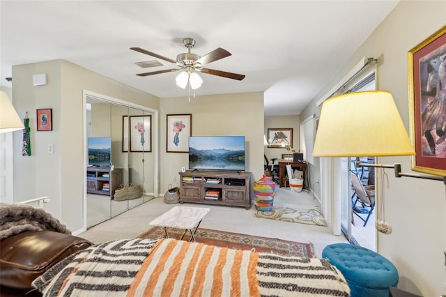 carpeted living room featuring baseboards, visible vents, and a ceiling fan