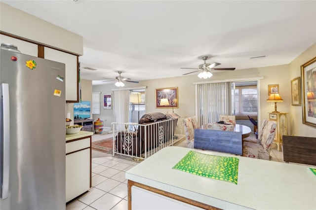 kitchen featuring light tile patterned floors, light countertops, visible vents, and freestanding refrigerator