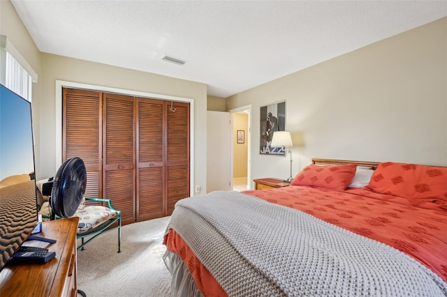 bedroom featuring carpet, a textured ceiling, visible vents, and a closet