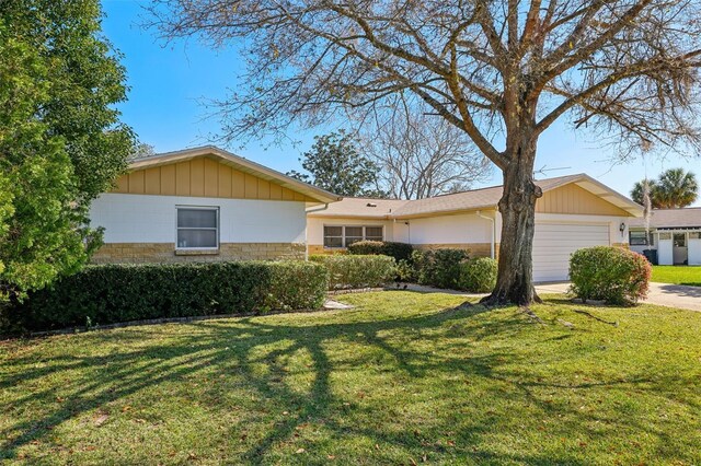 view of front of house with an attached garage, a front yard, and driveway