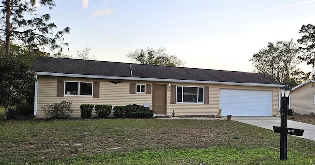 ranch-style house featuring an attached garage, driveway, and a front yard