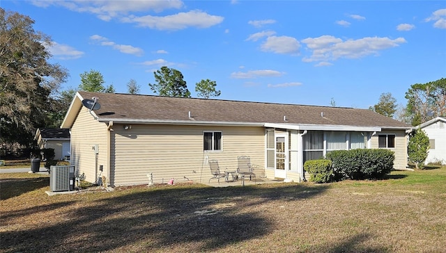 back of property featuring a sunroom, a patio, central AC, and a yard